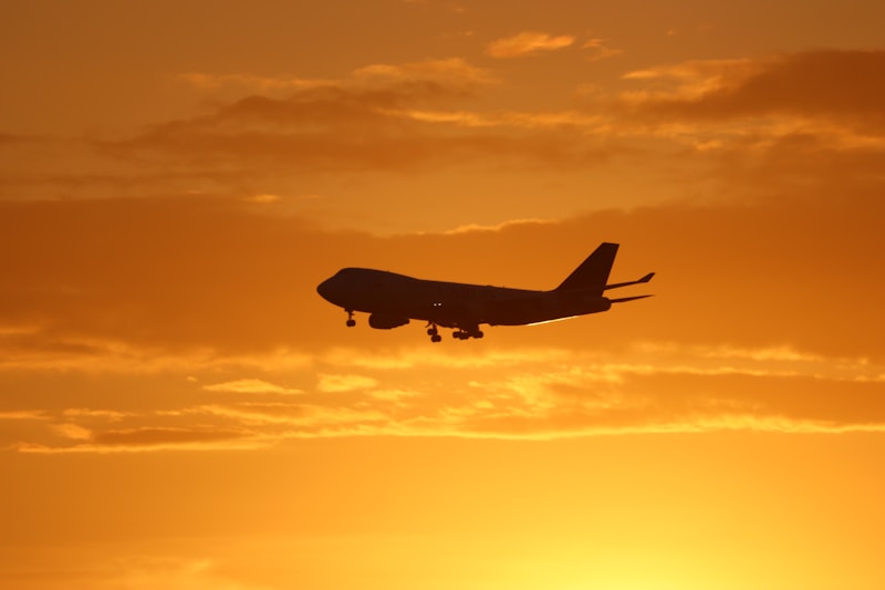 Airplane soaring under golden hour skies — your journey to a new life begins here