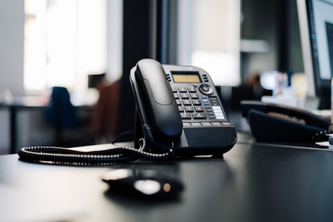 Office phone on desk — talk to our visa and immigration expert anytime